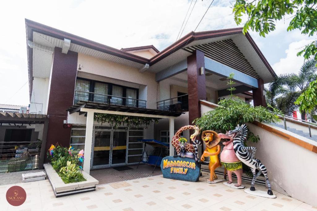 une maison avec deux statues devant elle dans l'établissement Quezon Premier Hotel - Candelaria, à Candelaria