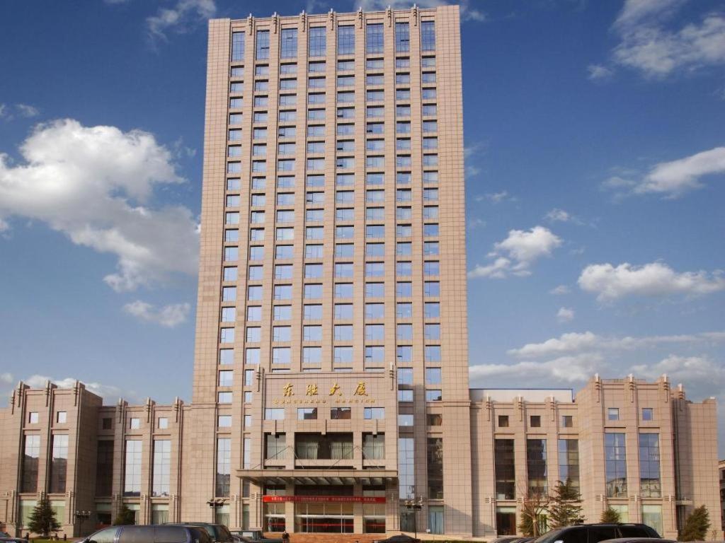 a large building with a sign on the front of it at Dongying Dongsheng Hotel in Dongying