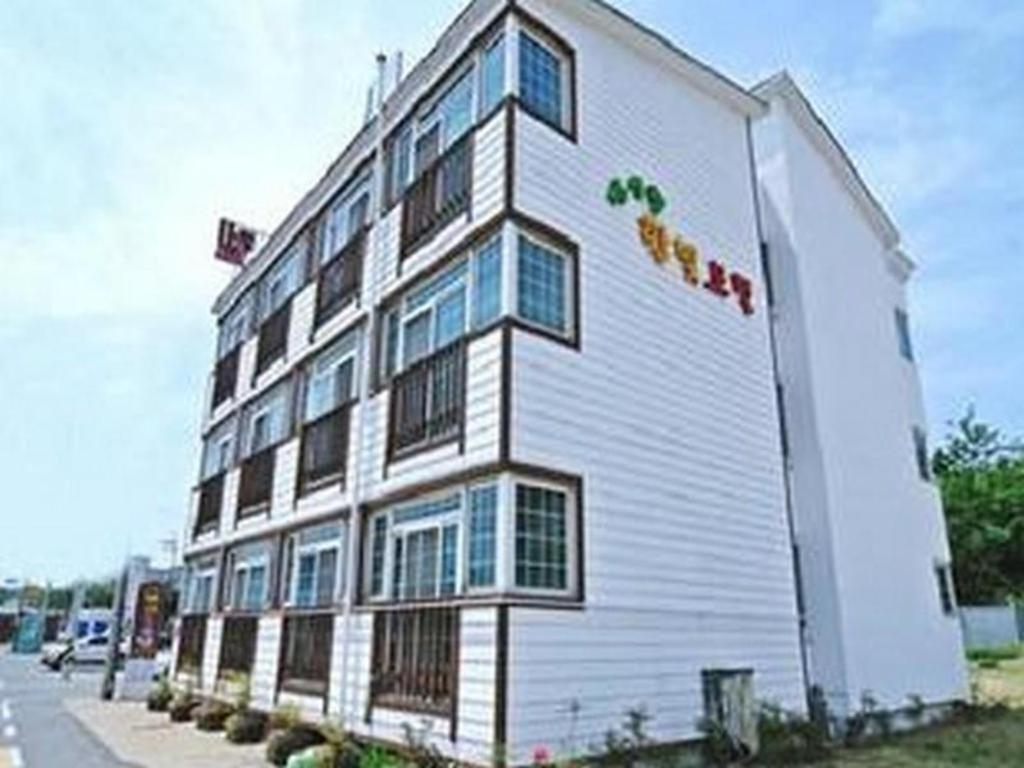 a large white building with windows on a street at Hanbit Pension & Motel in Taean