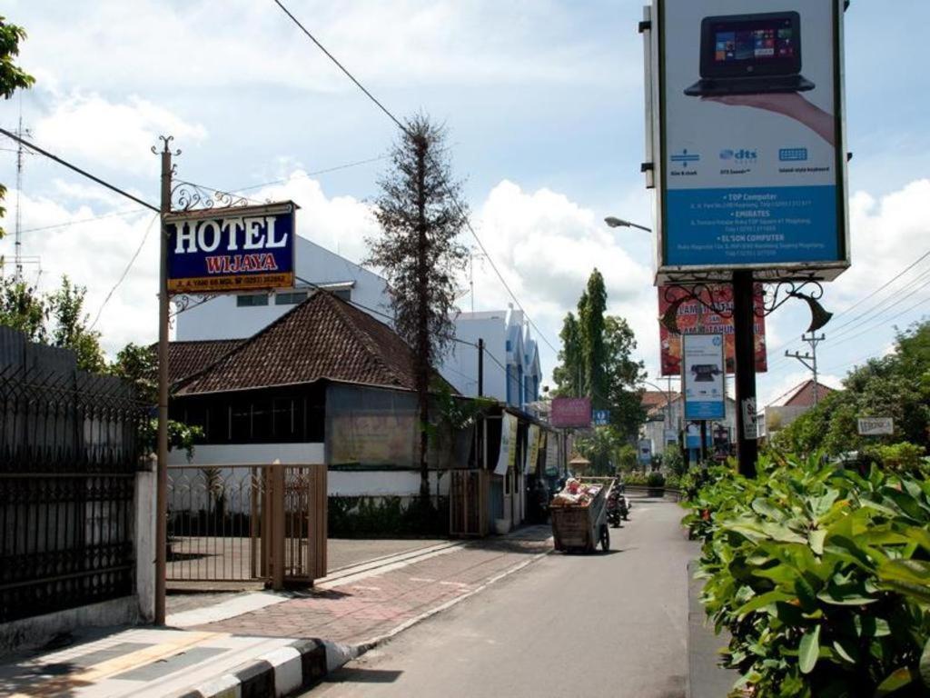 a sign for a hotel on the side of a street at Hotel Wijaya Magelang in Magelang