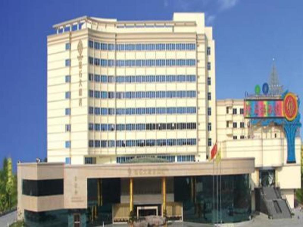 un grande edificio bianco con un cartello di fronte di Zhangzhou Longhai Diamond Hotel a Longhai