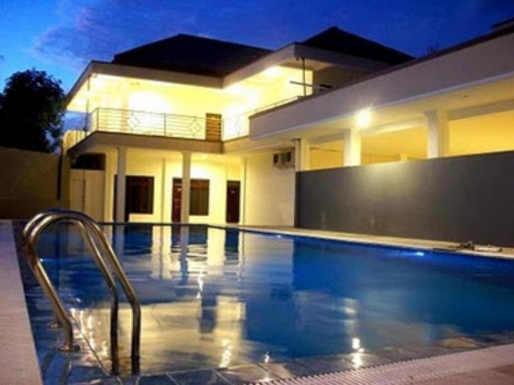 a swimming pool in front of a house at Grand Wisata Hotel in Ende