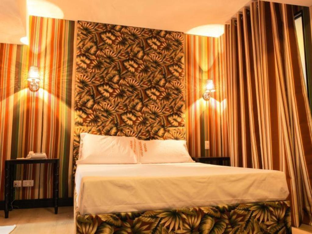 ein Schlafzimmer mit einem großen Bett und einer großen Wand in der Unterkunft Starmark Hotel in Naga