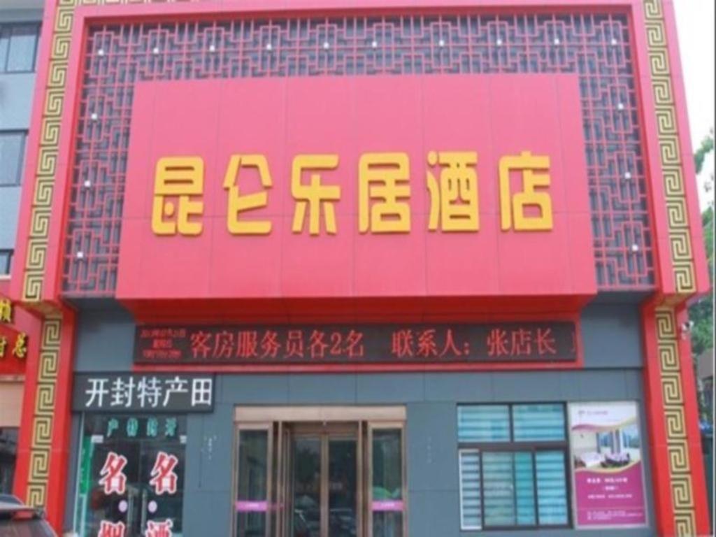 a building with a sign on the side of it at Kunlun Leju Business Hotel Kaifeng Gulou in Kaifeng