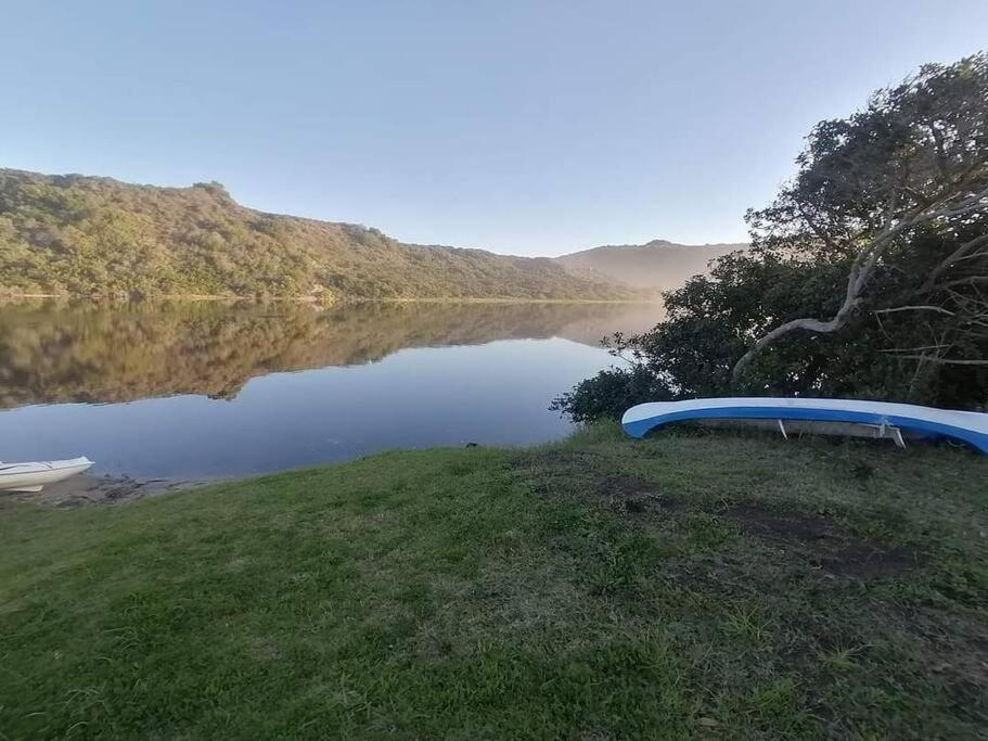 a blue canoe sitting on the side of a lake at Ria's Rest Self Catering Flatlet in Sedgefield