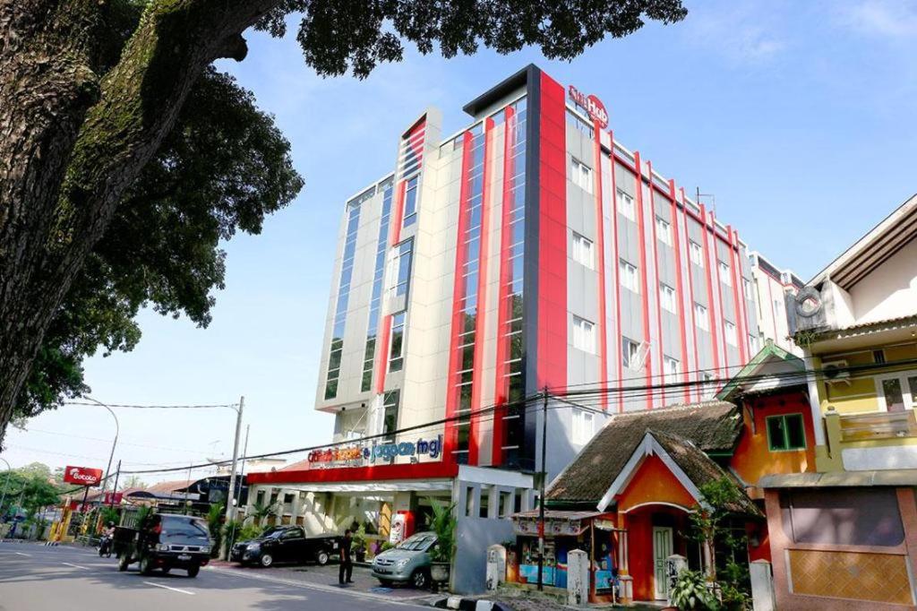 a red and white building on a city street at Citihub Hotel @Jagoan Magelang in Magelang