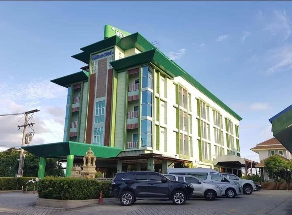 a building with cars parked in a parking lot at Chodkamol Place 57 in Nakhon Si Thammarat