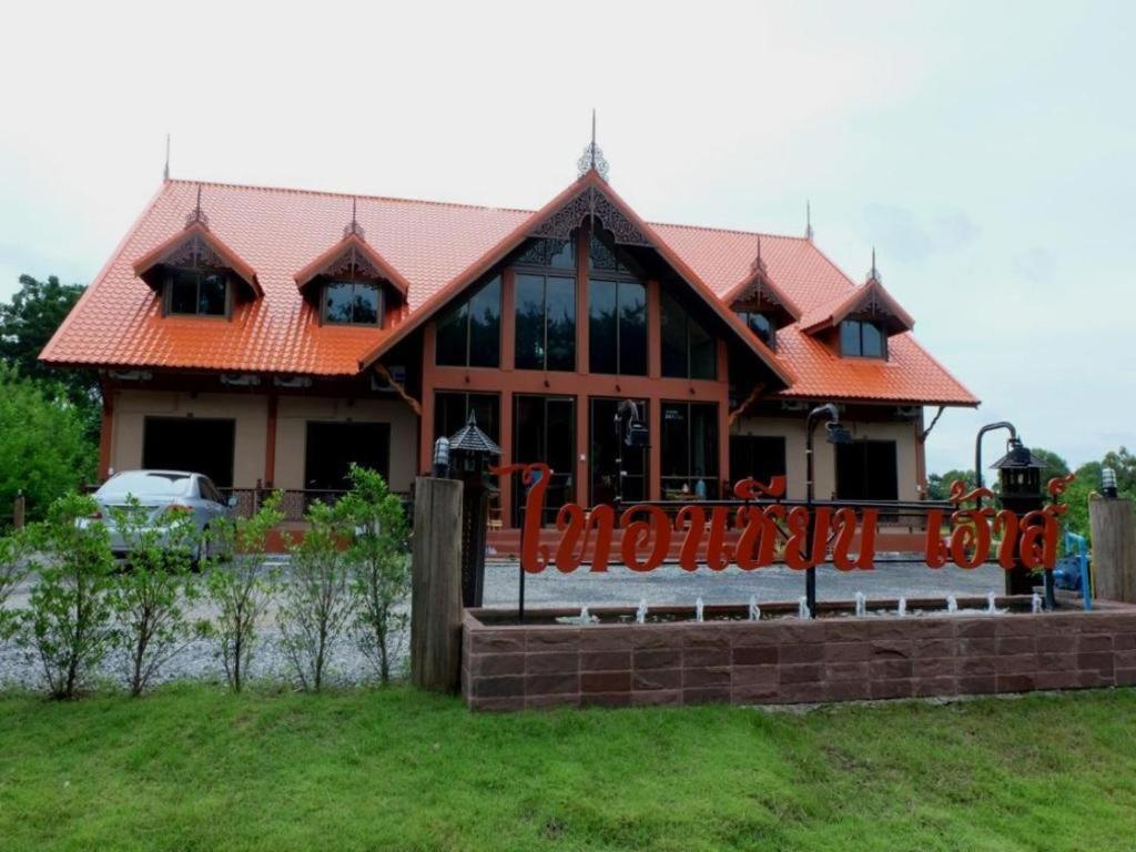 ein großes Haus mit orangefarbenem Dach in der Unterkunft Tai Asean House in Ban Kham Kling