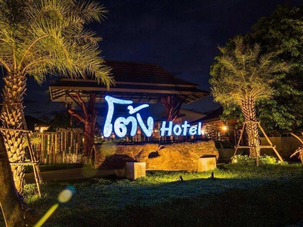 un panneau indiquant un hôtel est allumé la nuit dans l'établissement Tong Hotel, à Ban Nong Chik