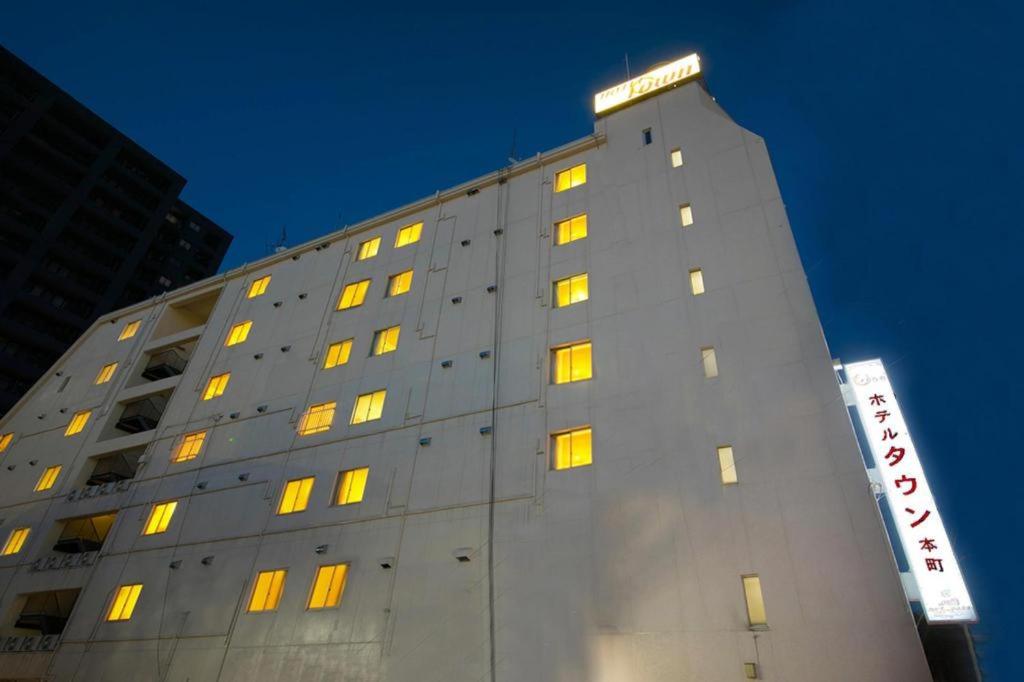 un edificio alto con luces amarillas. en Hotel Town Honmachi en Kochi