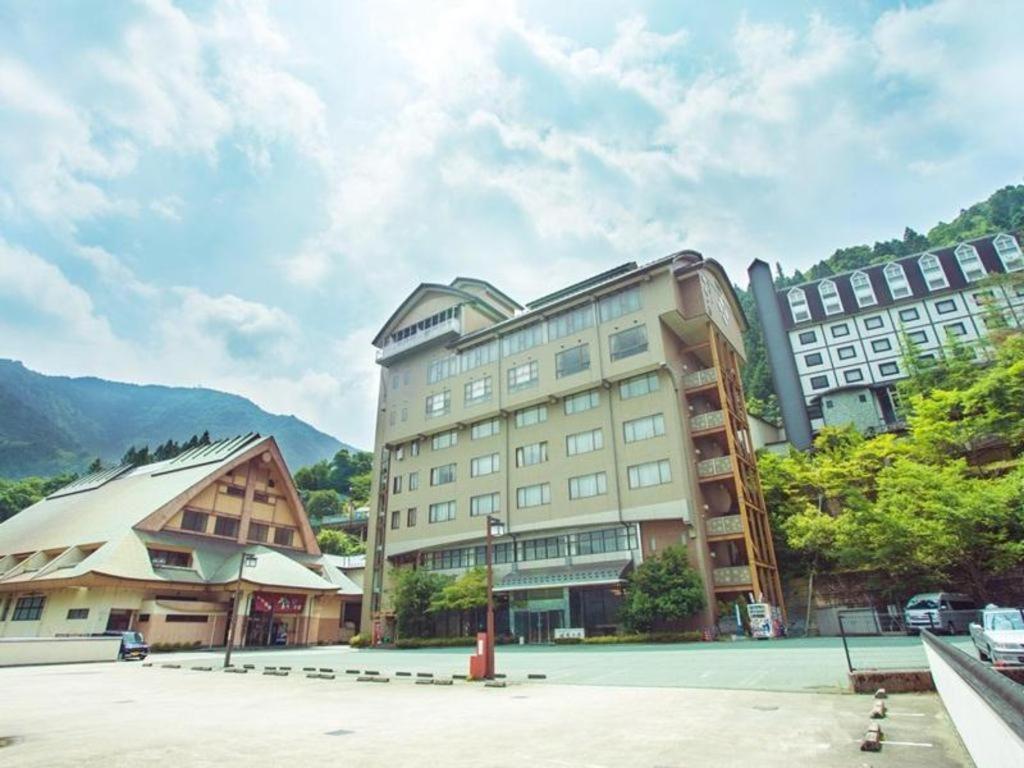 un gran edificio con una pista de tenis enfrente en Hotel Hikyounoyu, en Itchū