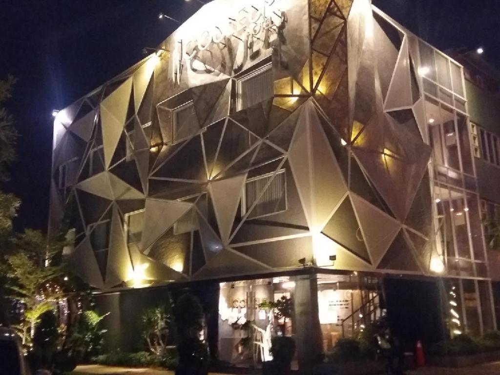 un edificio con facciata geometrica di notte di Couleur Hotel Cengkareng a Giacarta