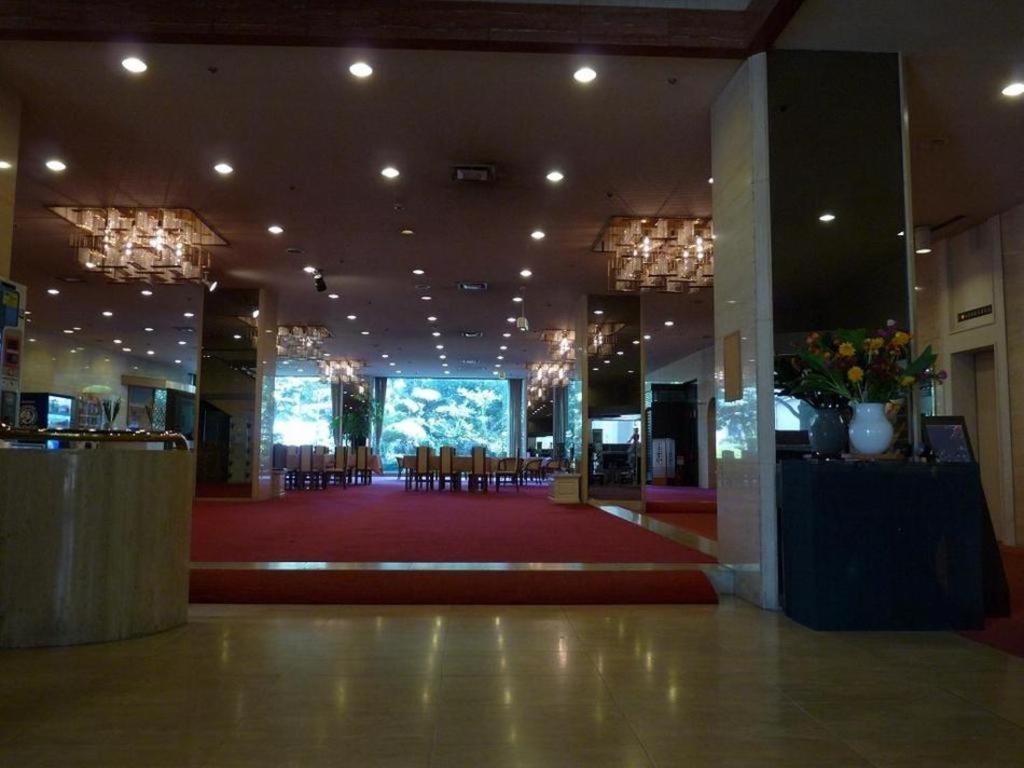 een grote lobby met stoelen en een rode loper bij Miyakonojo Royal Hotel in Miyakonojo