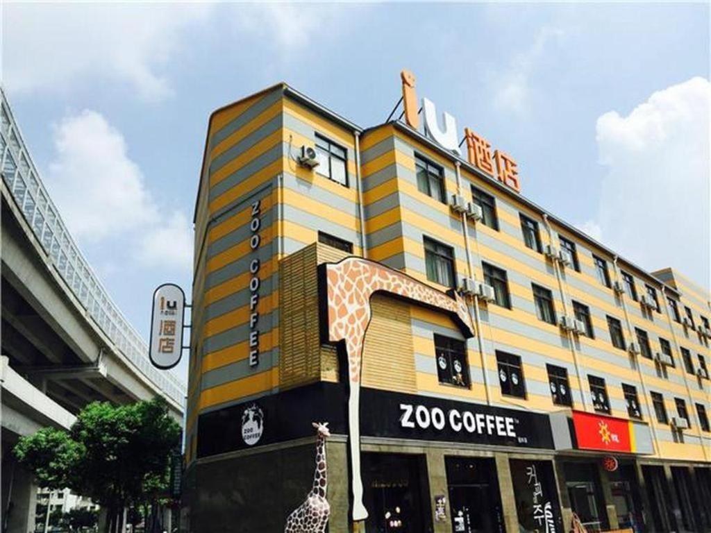 ein großes Gebäude mit einem Zookaffeeschild drauf in der Unterkunft IU Hotel Shanghai Jiaotong University Jiangchuan Road Metro Station 