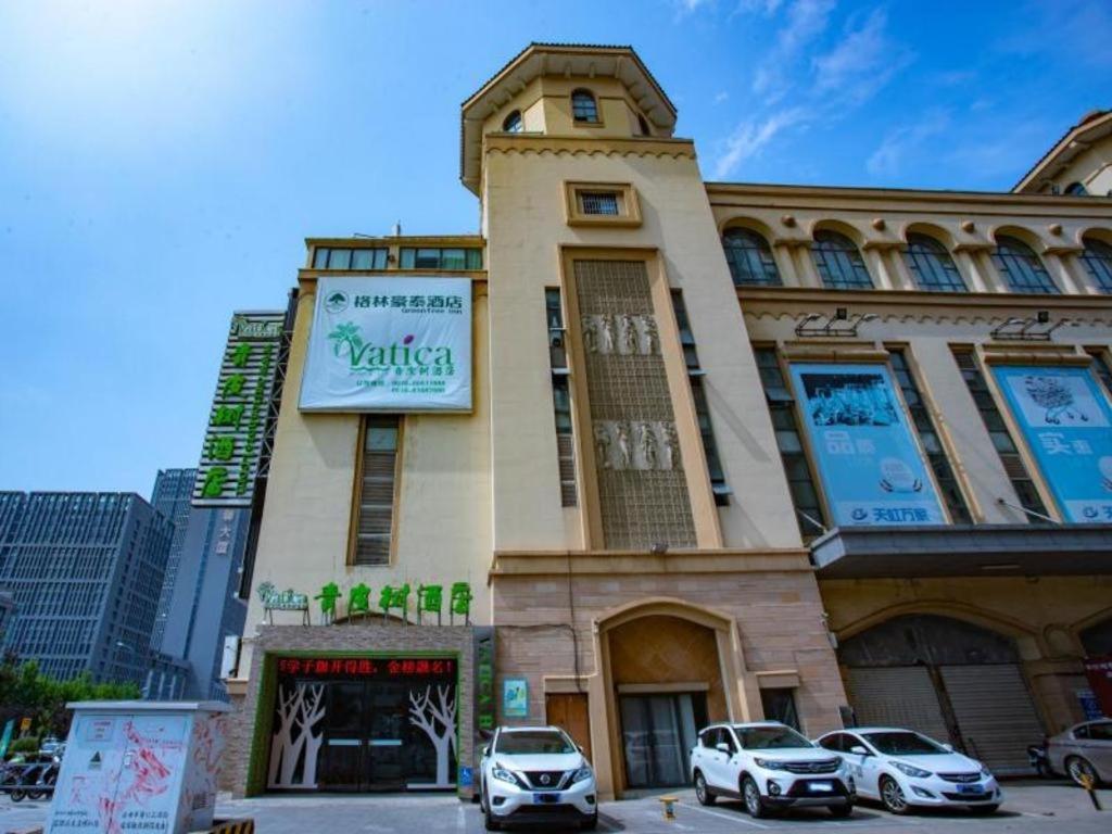 a building with cars parked in front of it at Vatica Lianyungang Haizhou Xinkong South Road Zhongyin Mingdu Hotel in Yuhang