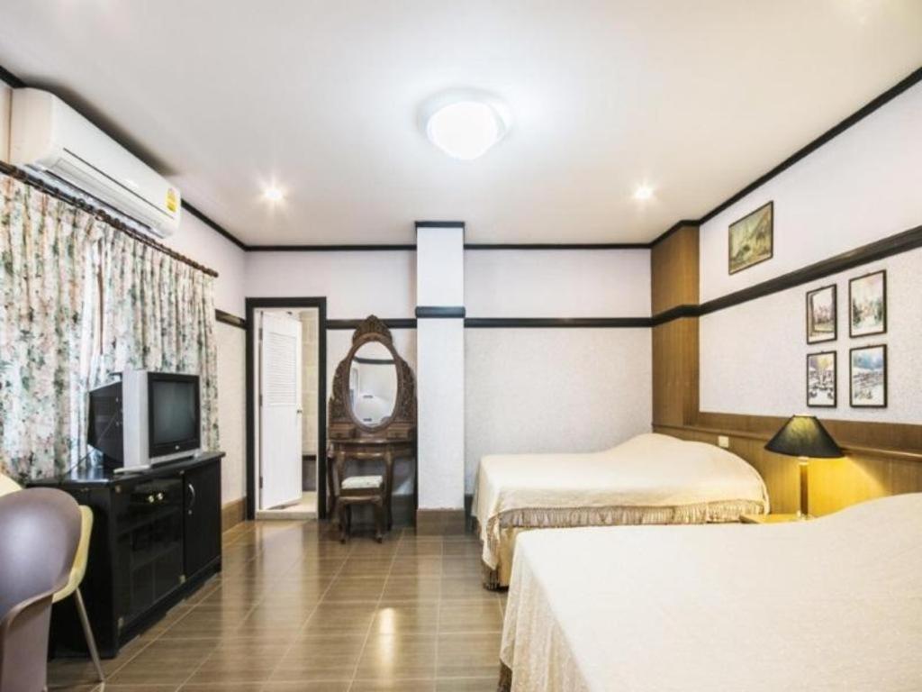 um quarto de hotel com duas camas e uma televisão em Numsin Hotel em Ban Rong Chang