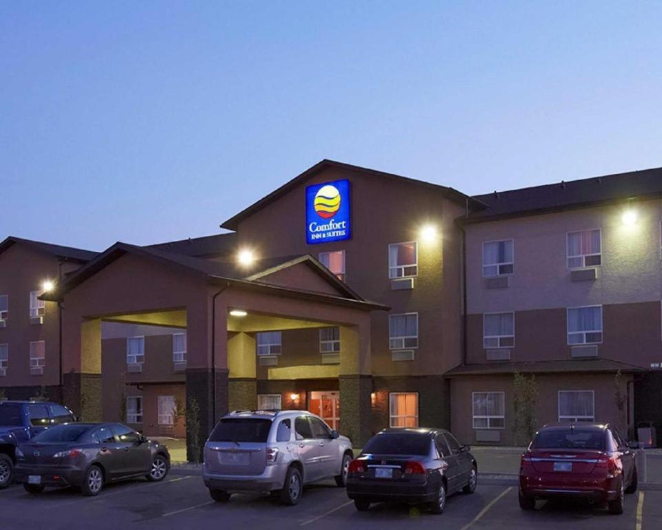 a hotel with cars parked in a parking lot at Comfort Inn & Suites in Virden