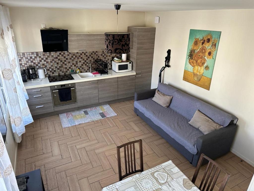 a living room with a couch and a kitchen at Duplex 10 mn de Paris in Alfortville