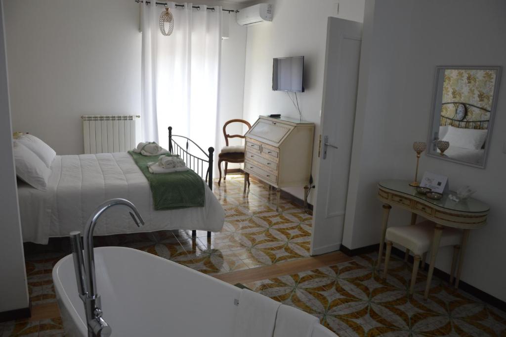 - une chambre avec un lit et une salle de bains pourvue d'une baignoire dans l'établissement I colori della Sicilia NOBLESSE, à Caltagirone