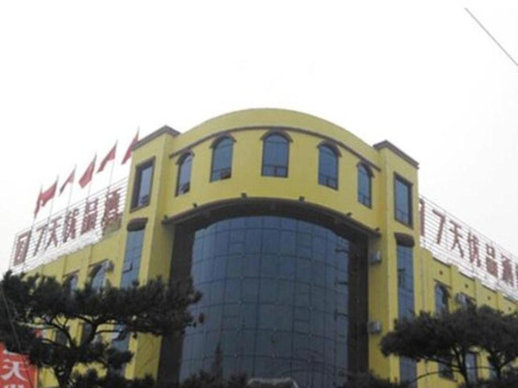 a large yellow building with a large window at 7 Days Premium Rizhao Ju County Ancient City in Rizhao