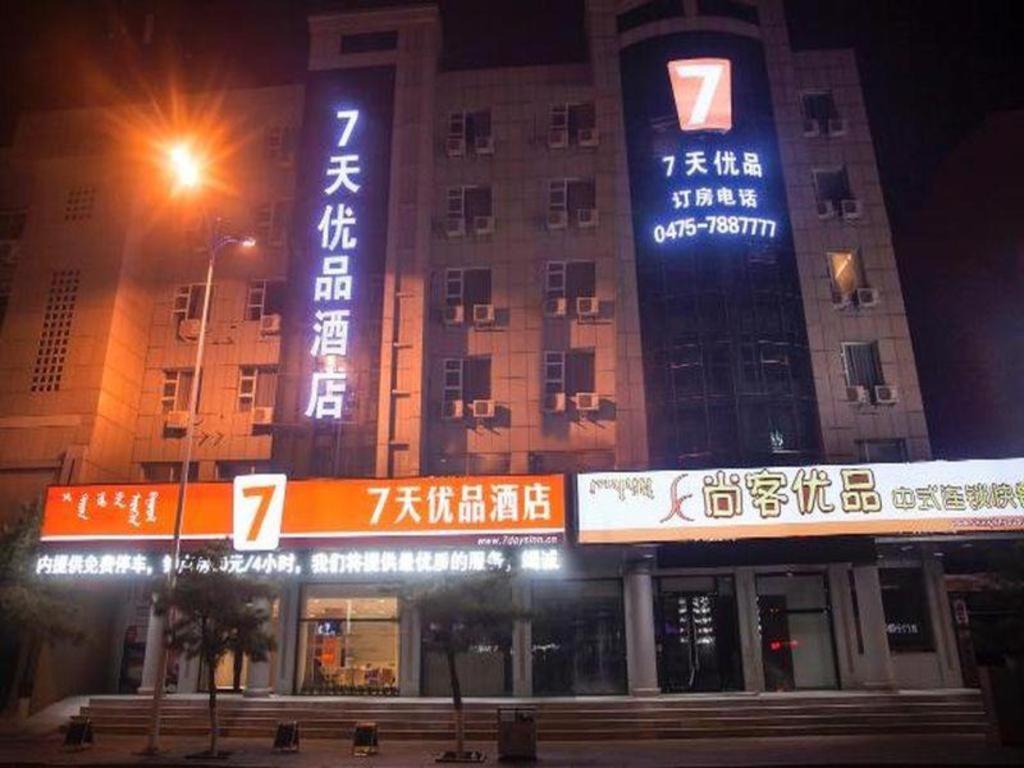 um grande edifício com cartazes à noite em 7 Days Premium Tongliao Train Station Branch em Tongliao