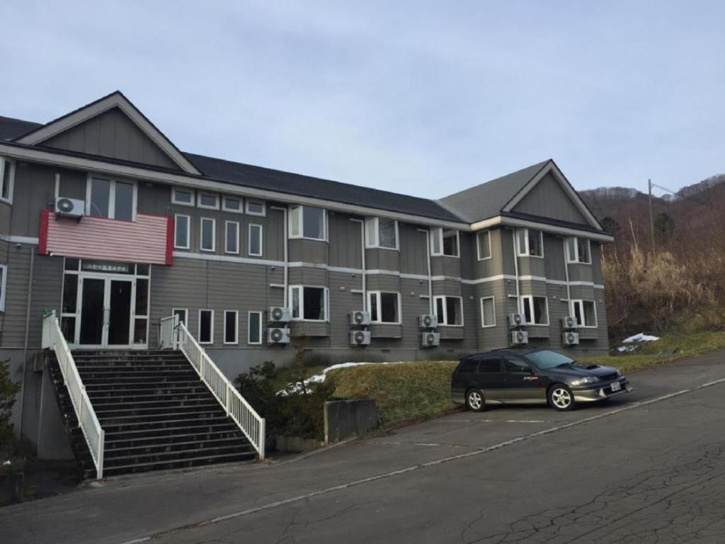 un edificio con un coche aparcado en un aparcamiento en Niyama Onsen Hotel NK Vila, en Tōgenoshita