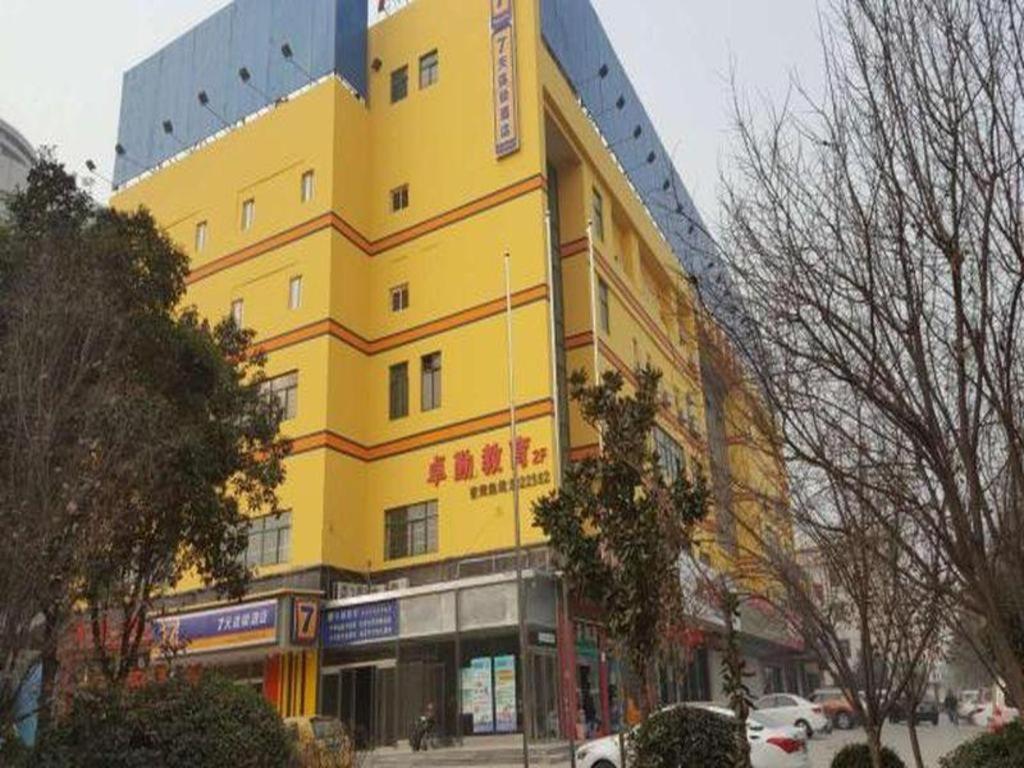 een geel gebouw aan de straatkant bij 7 Days Inn Weinan Dongfeng Street in Weinan