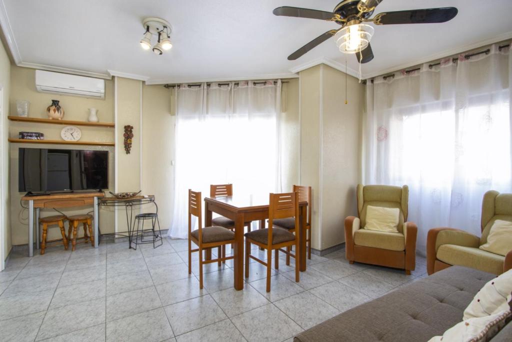 een woonkamer met een tafel en stoelen en een bank bij ALEGRIA ID144 in Torrevieja