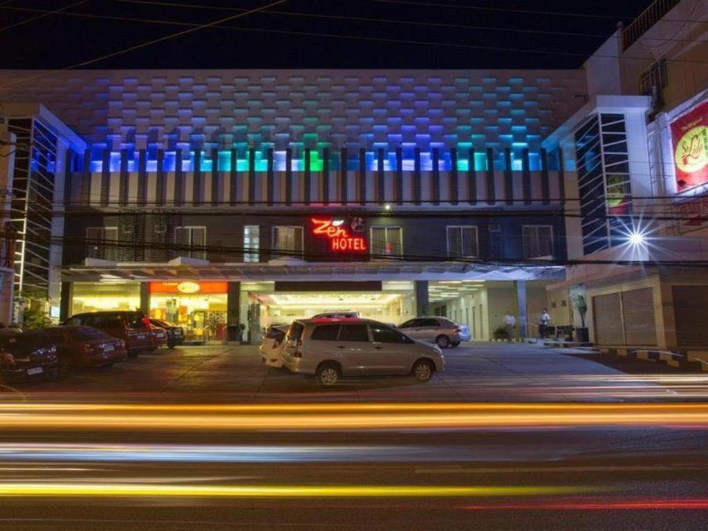 un edificio con coches estacionados en un estacionamiento por la noche en Isabela Zen Hotel & Restaurant Corporation, en Santiago