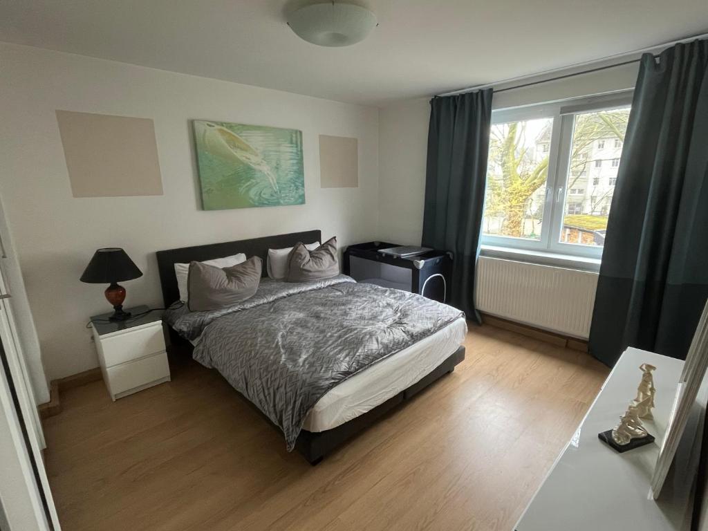 um quarto com uma cama e uma grande janela em Gemütlich em Essen