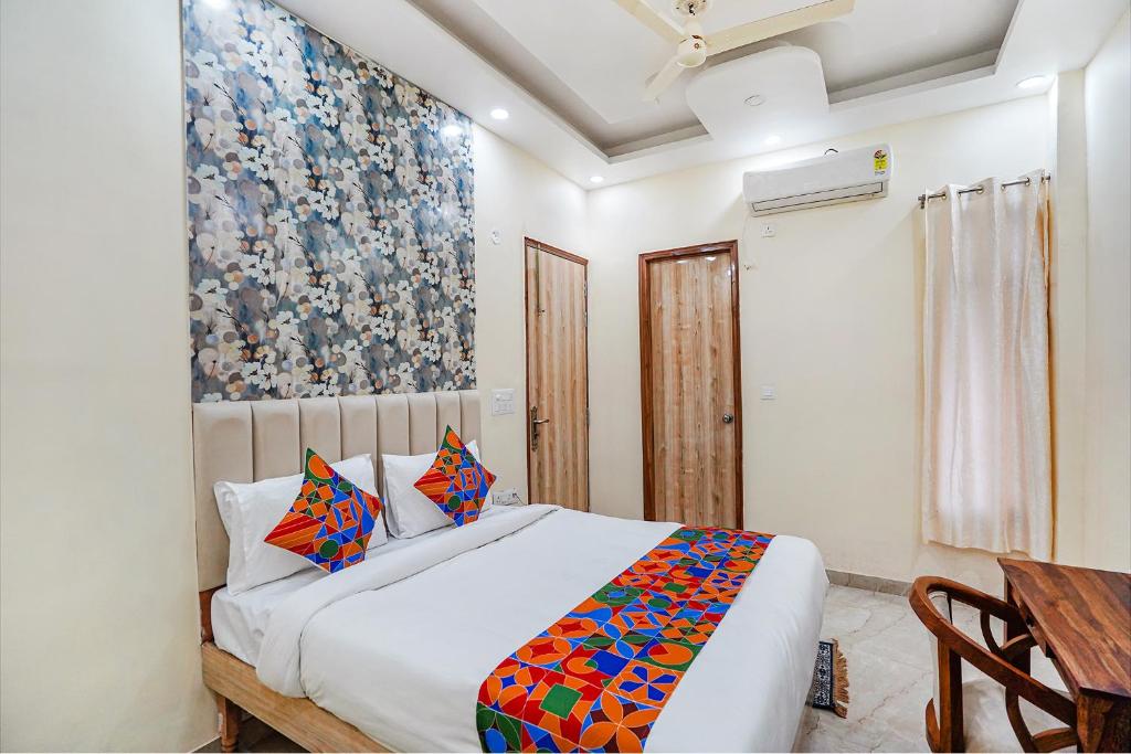 een slaapkamer met een bed en een schilderij aan de muur bij FabHotel ADA Residency in Noida