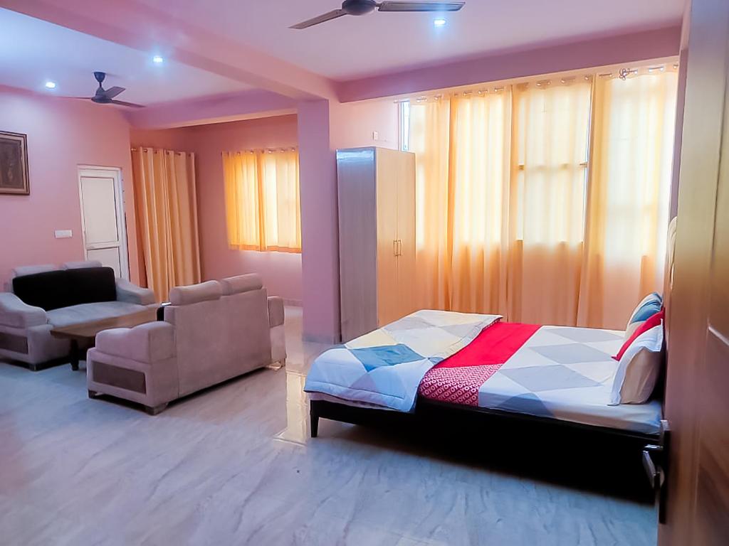 een slaapkamer met een bed, een bank en een stoel bij Bharat Vandana Stay near Yashobhoomi in New Delhi