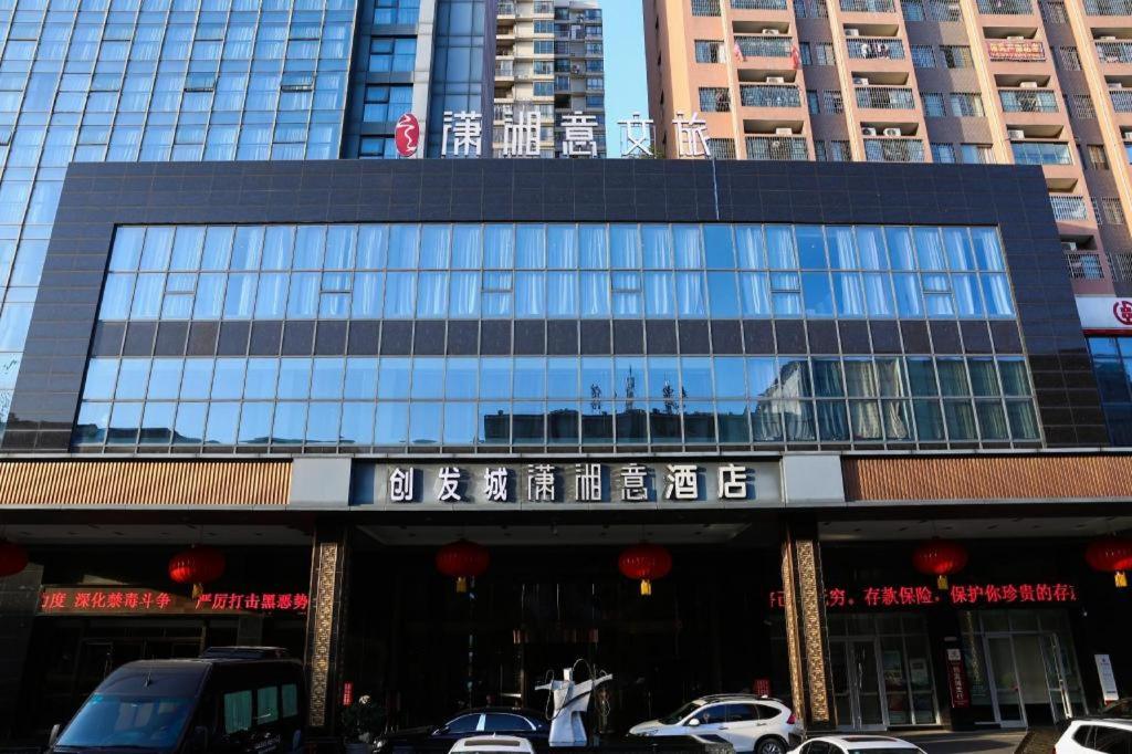 ein Gebäude mit einem Schild auf der Vorderseite in der Unterkunft Yongzhou Chuang Fa Cheng XiaoXiangYi Hotel in Guzhuting