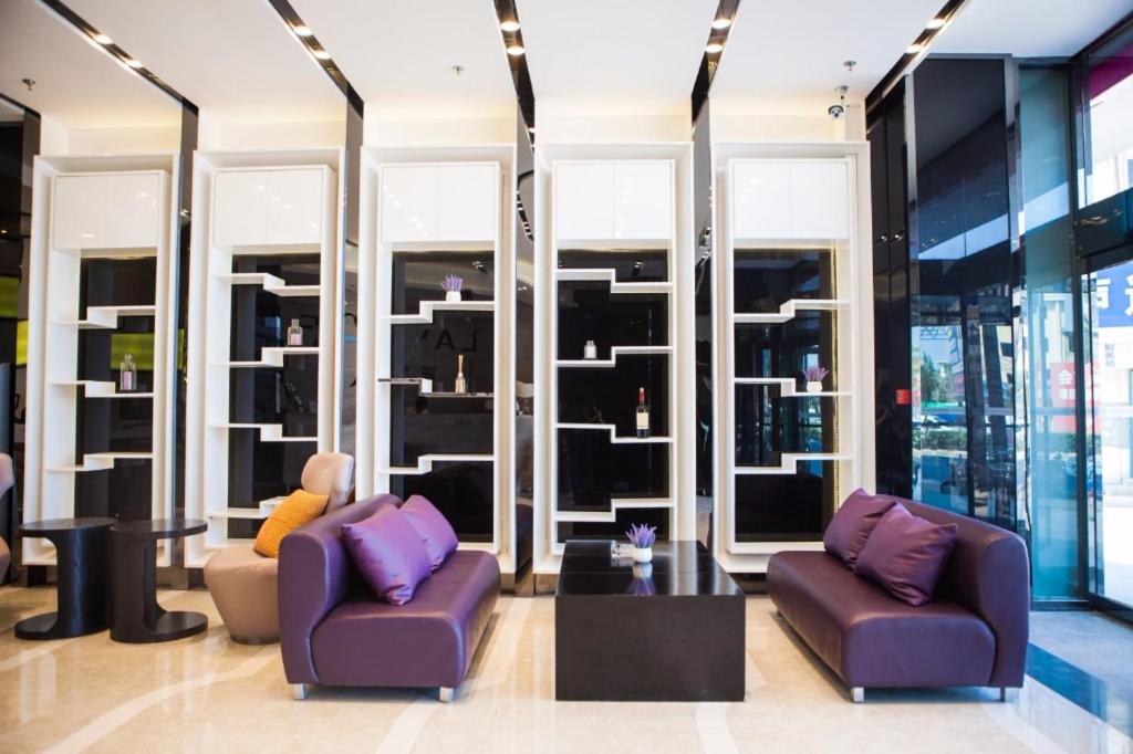 two chairs and a table in a room with windows at Lavande Hotel Yantai Train Station Branch in Yantai