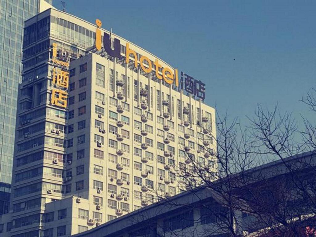 a large building with a sign on top of it at IU Hotel Baoding Goverment Shidai in Baoding