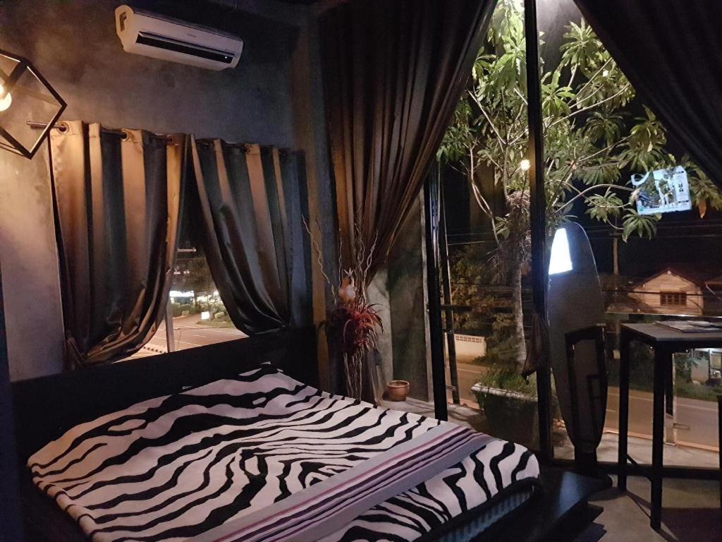 Ban Noi Pho KhamにあるTheloft boutique nakhonpanomの窓付きの客室で、シマウマプリントのベッド1台が備わります。