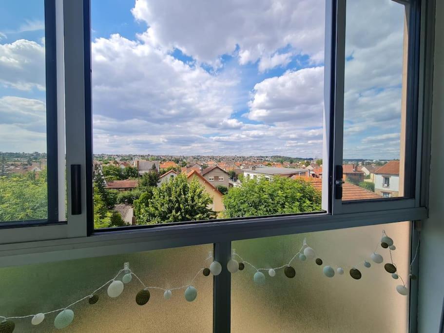 a window with a view of a city at T3 cosy proche Paris, tous commerces et Rer à pied in Viry-Châtillon