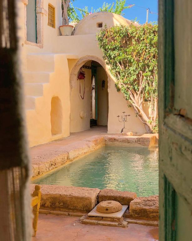 an alley with a pool of water in a building at Dar Kenza in Djerba