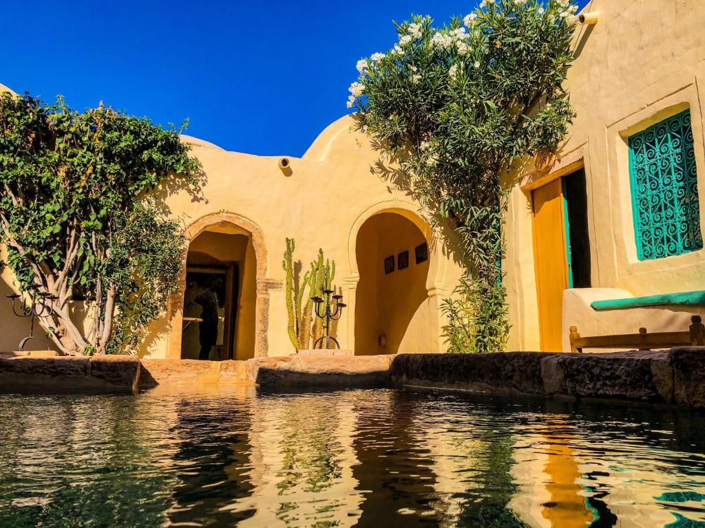 una casa con una piscina d'acqua di fronte di Dar Kenza a Djerba
