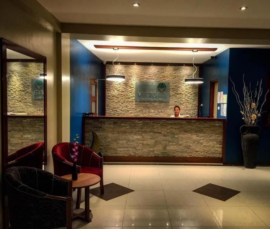 a person standing behind a bar in a waiting room at Victoria Palms Hotel in Suva