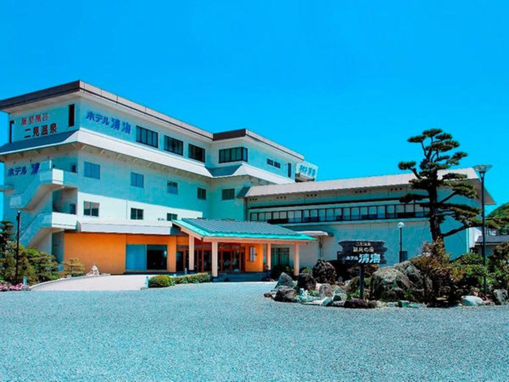ein großes Gebäude mit einem Baum davor in der Unterkunft Futami Onsen Hotel Seikai in Hutami
