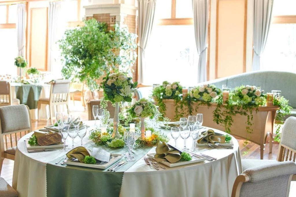 a table with a white table cloth and wine glasses at Hotel Grand Shinonome in Tsukuba