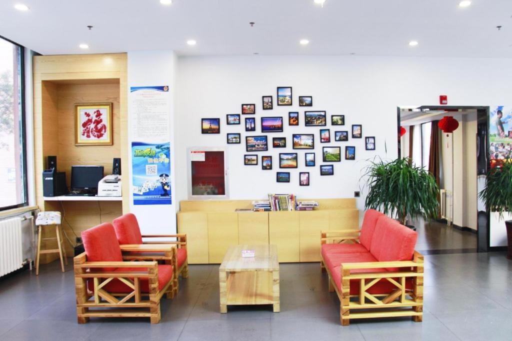 une salle d'attente avec des chaises, une table et des photos sur le mur dans l'établissement 7 Days Premium Beijing Dabaotai Metro Station Luhua Road, à Pékin