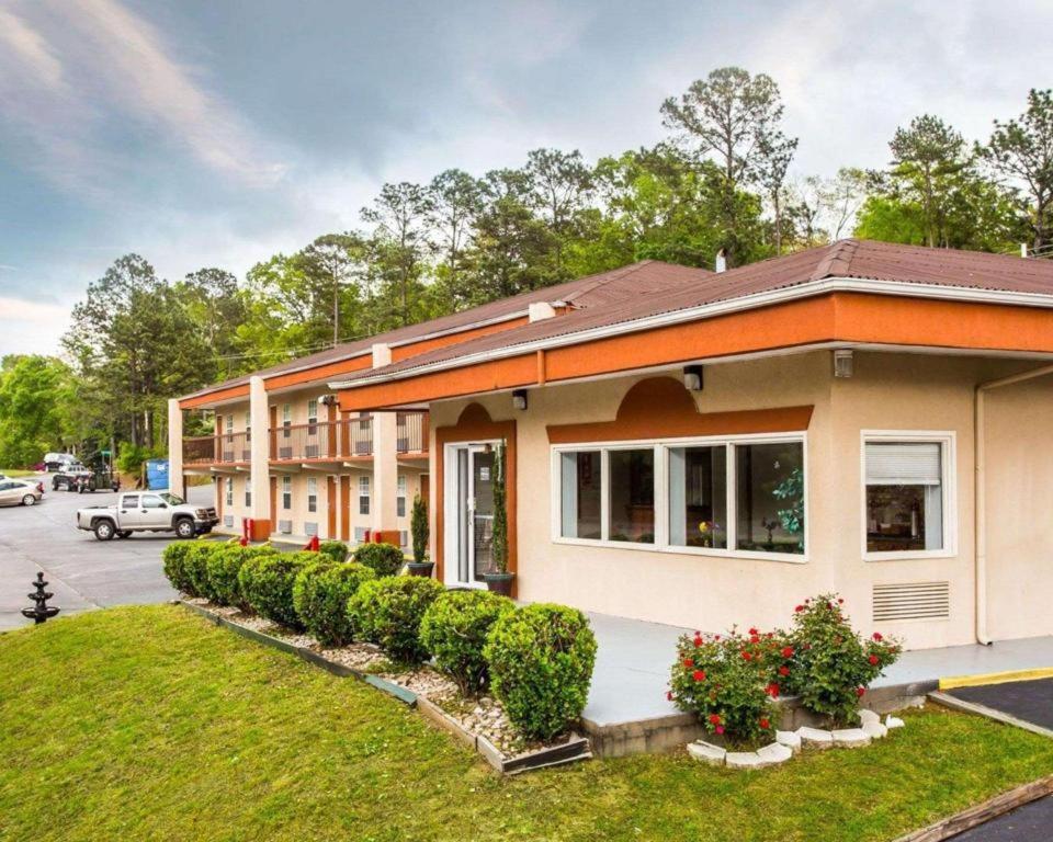 a house with bushes in front of a parking lot at Econo Lodge Columbia Fort Jackson in Burnside East