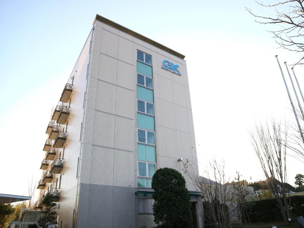 a tall white building with a sign on it at KEIKYU EX INN Yokosuka Research Park in Kubiri