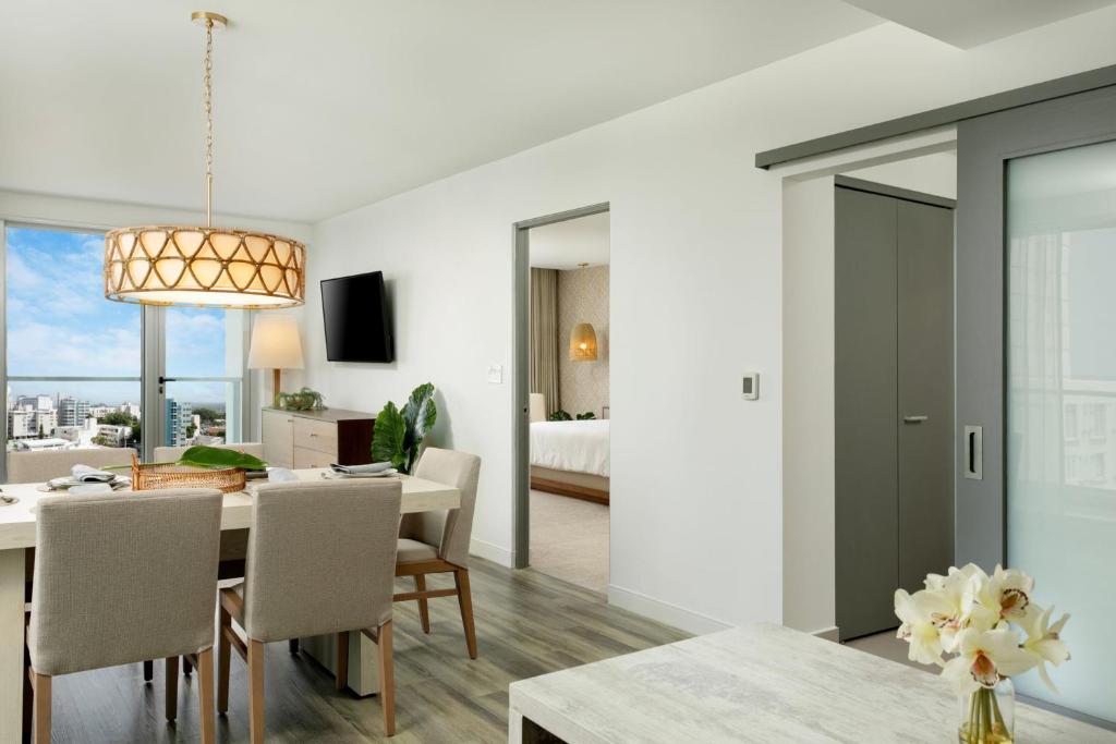 a dining room and living room with a table and chairs at Casa Costera, Isla Verde Beach, Apartments by Marriott Bonvoy in San Juan