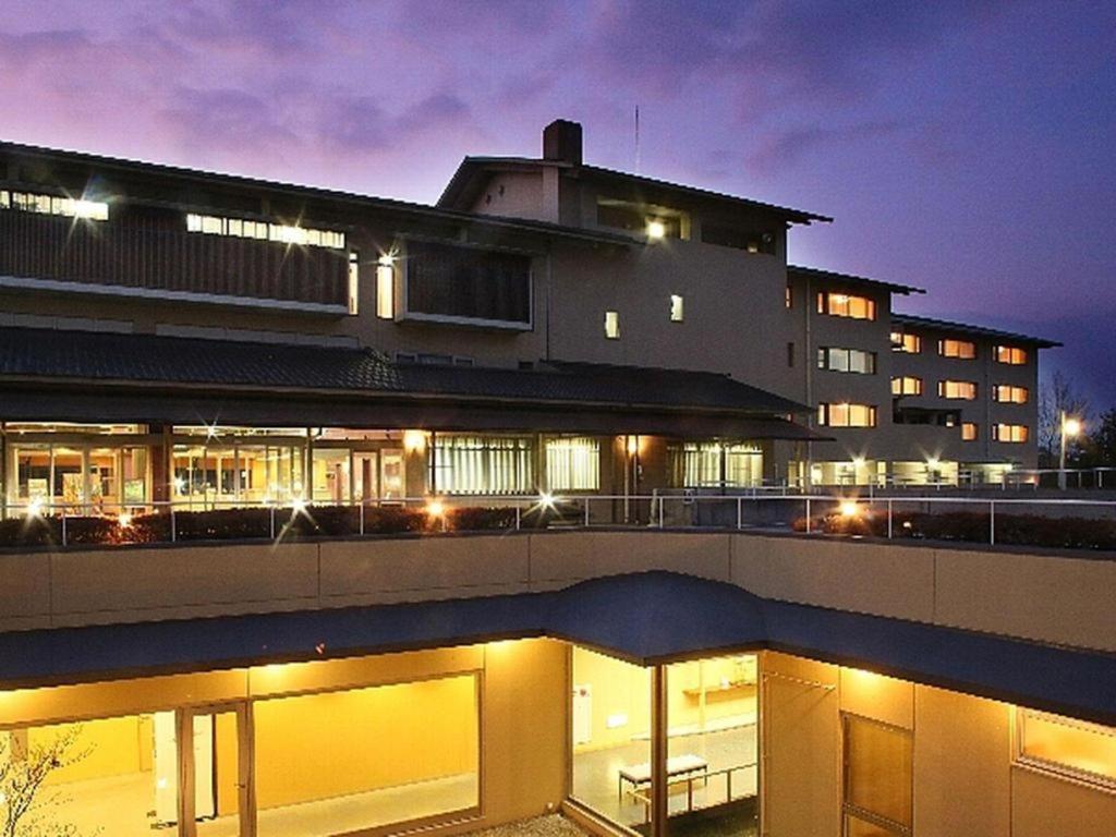 un edificio con luces delante de él por la noche en Hotel Sakushu Musashi en Mimasaka