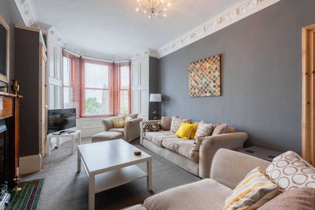 a living room with a couch and a tv at Bridge View Apartments in Dundee