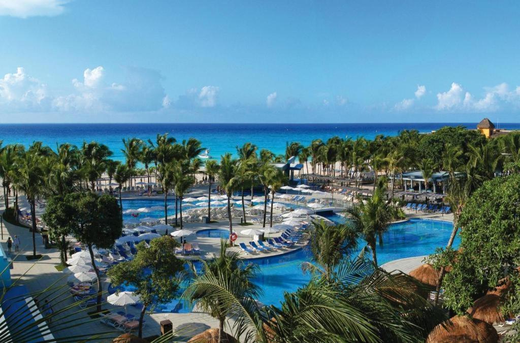 an aerial view of a resort with palm trees and pools at Riu Yucatan - All Inclusive in Playa del Carmen