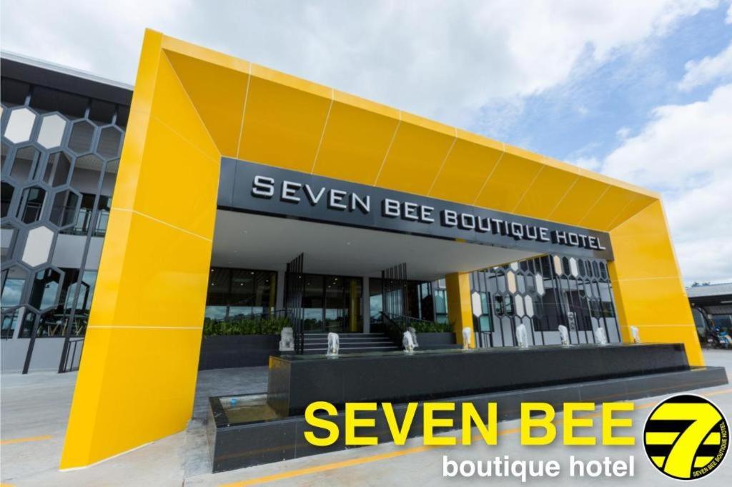 un edificio amarillo frente a un edificio en Seven bee boutique hotel, en Surin